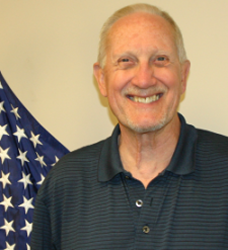 Bill Blanchard smiling in front of the American Flag after the war