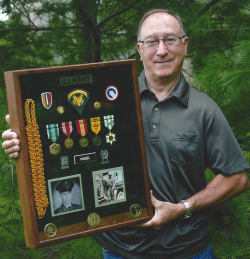 Robert Knebel years later holding a case that has all his awards from the Army