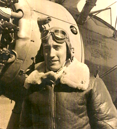 Charles Laudie standing in front of a military plane wearing his avator jacket