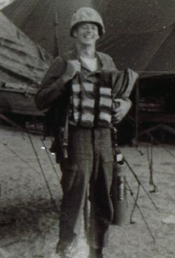 Donald Flack smiling in his military gear within the camp