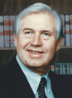 phot of Earl Riley in a suit in front of a book shelf