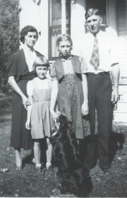 Charles Frauenholtz standing outside a house with his wife, 2 daughters and family dog