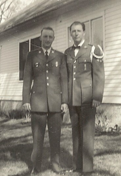 Harry Willey standing in front of a house in his Air Force uniform with a fellow solider