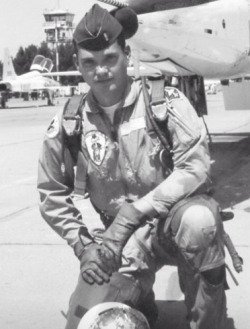 Jay Hansen kneeling in front of a Air Force plane in uniform