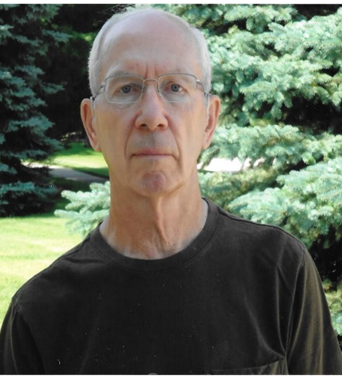 Jerry Mitchell years later standing in front of an Evergreen tree