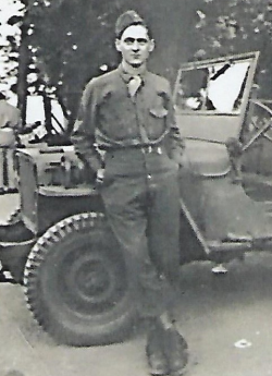 John McDonough lean against a military jeep