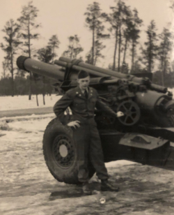 Irving Rockafellow standing in front of a cannon during the war