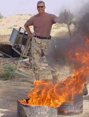 Rodney Walls standing in front of a bonfire during the war