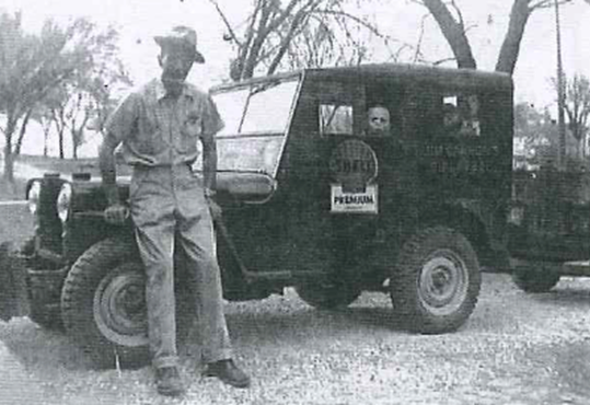 Thomas Cannon in the front window with his dad standing in front of the car about 1950