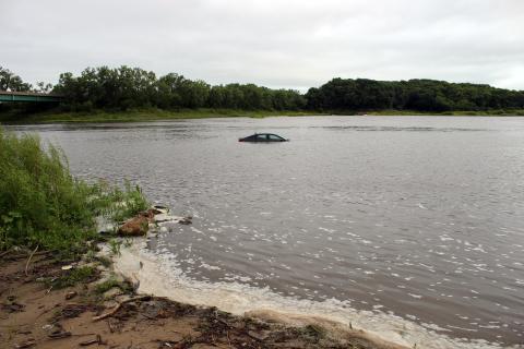 A car sits partially submerged in the Iowa River at the Curtis Bridge Boat Ramp.