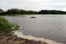 A car sits partially submerged in the Iowa River at the Curtis Bridge Boat Ramp.