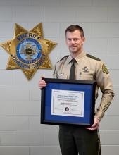 Major Randy Lamm of the Johnson County Sheriff's Office stands with the certificate of accreditation from the Iowa Law Enforcement Accreditation Program. 